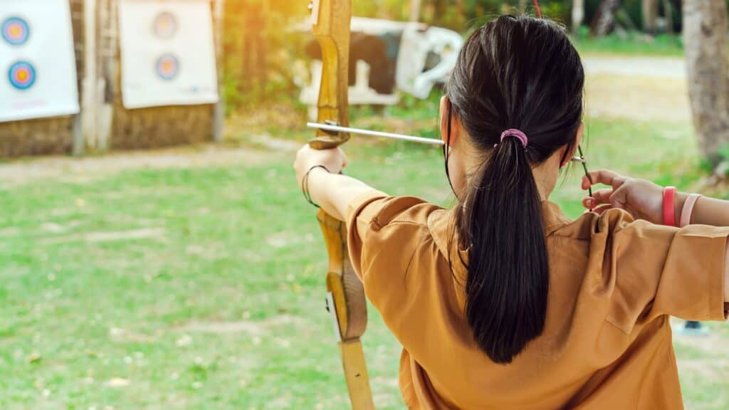 Back,View,Of,Asian,Girl,Wear,Face,Mask,Aims,Archery